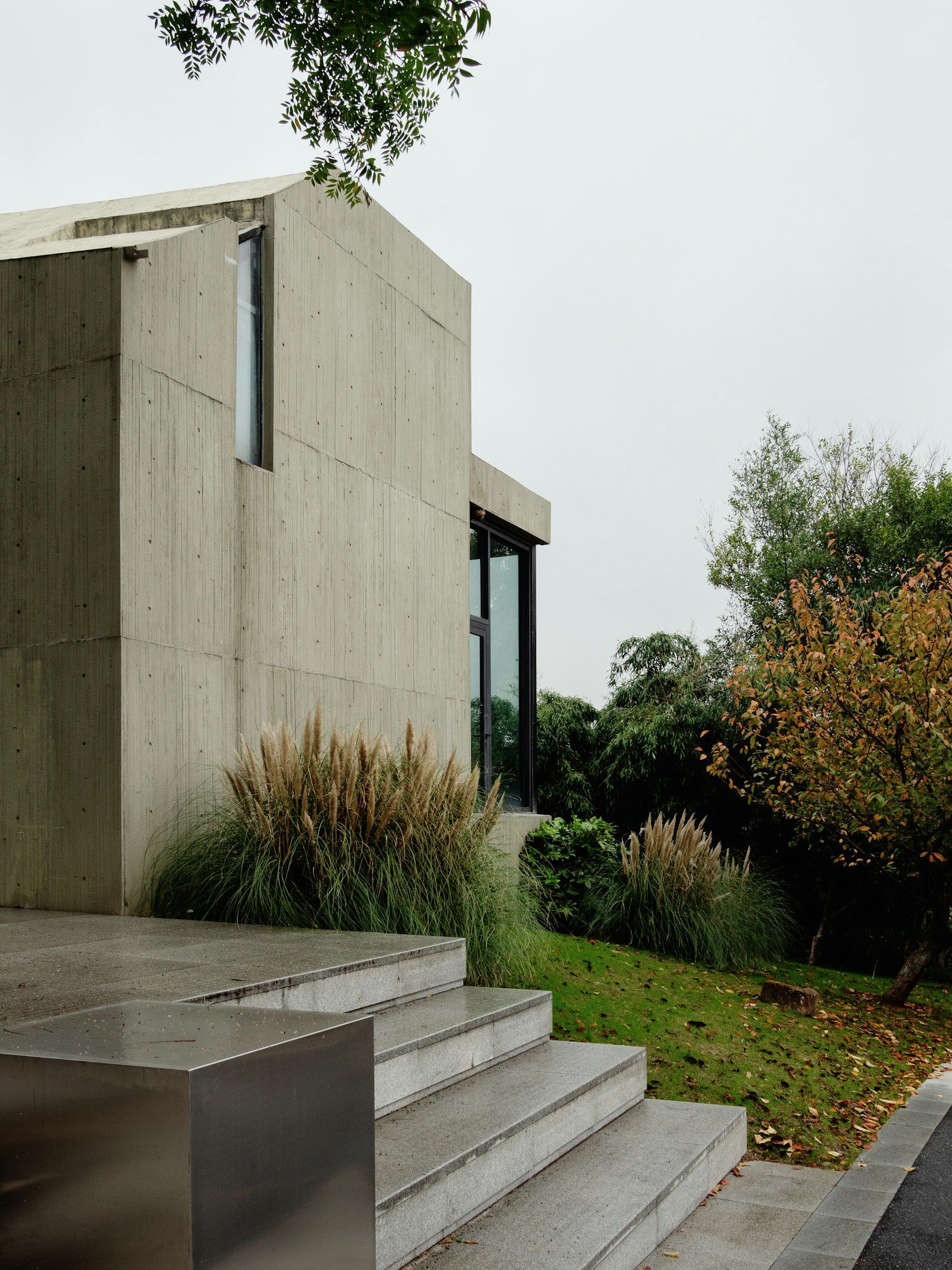 A board-marked concrete house among trees
